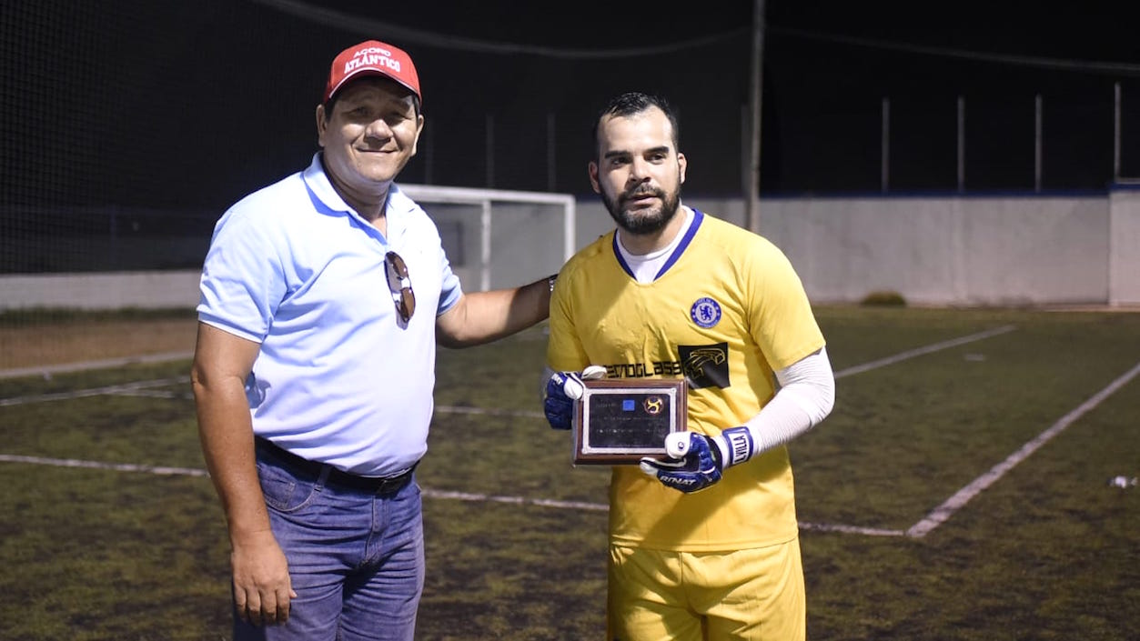 El periodista Boris Páez Guzmán entrega el trofeo a Andrés Villa como mejor arquero.