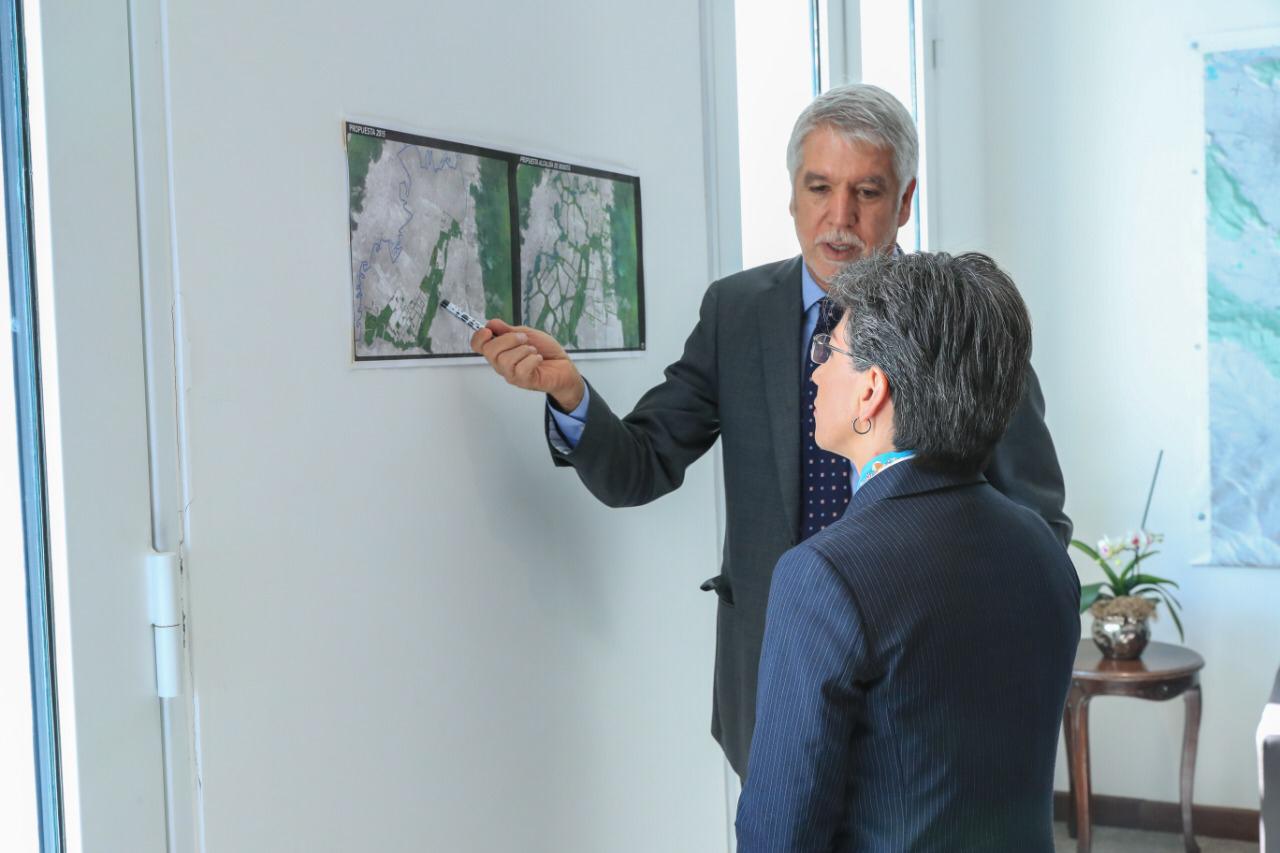 El actual Alcalde de Bogotá, Enrique Peñalosa, enseña a la alcaldesa electa un plan de las obras.