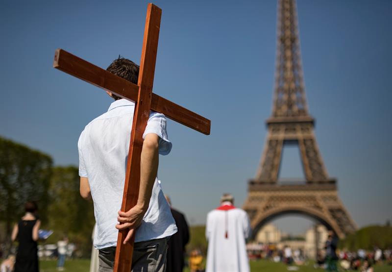 Numerosas personas participando en una ceremonia junto a la Torre Eiffel en París (Francia).