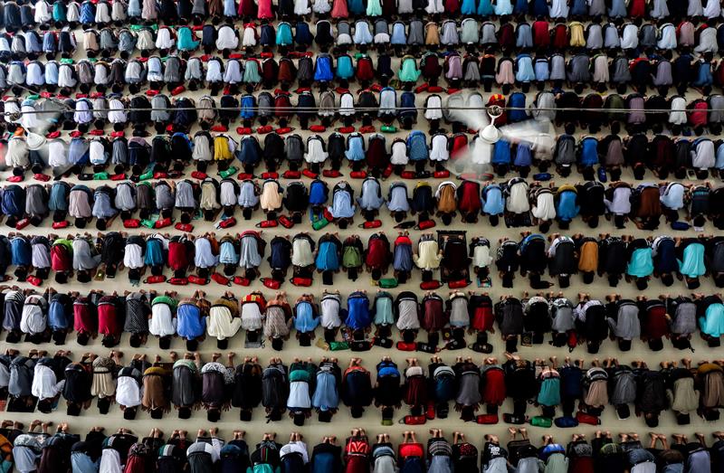 Cientos de estudiantes indonesios realizan la oración de la tarde en el primer día de Ramadán, este lunes, en Medan, Indonesia.