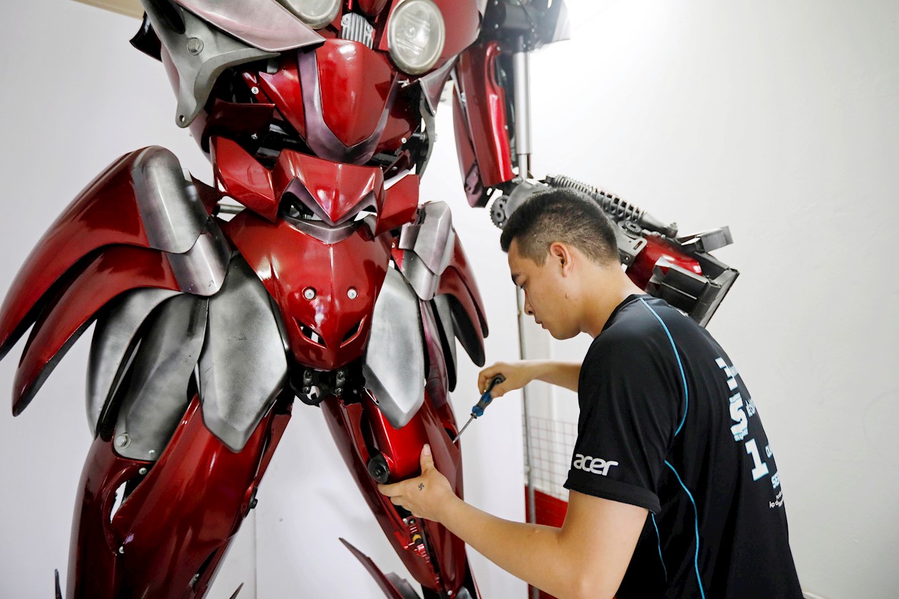 Do Danh Phong, miembro del equipo de Robot Bank, ajusta un robot hecho de plástico en una tienda en Hanoi, Vietnam.