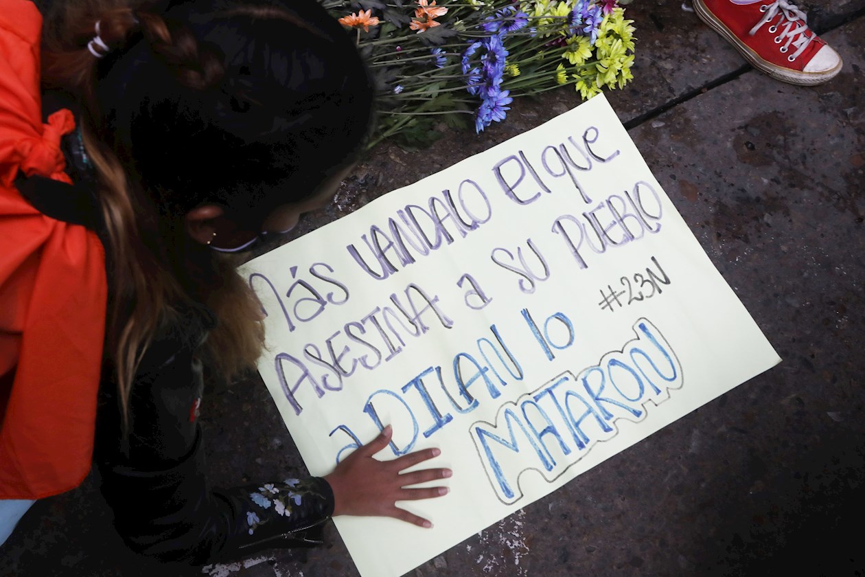 Una mujer sostiene un cartel durante la conmemoración del primer año de la muerte del estudiante Dilan Cruz hoy, en Bogotá (Colombia). 