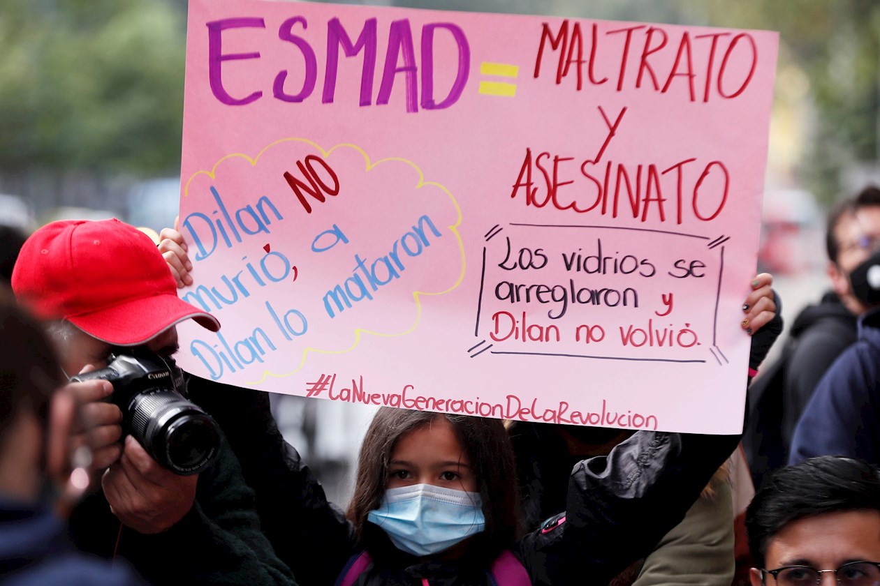 Una mujer sostiene un cartel durante la conmemoración del primer año de la muerte del estudiante Dilan Cruz hoy, en Bogotá (Colombia).
