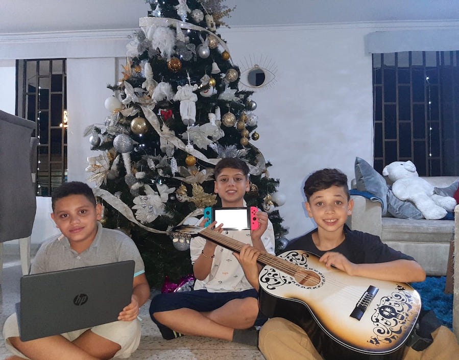 Sebastián con sus primos Lukas y Dylan, mostrando los regalos navideños.