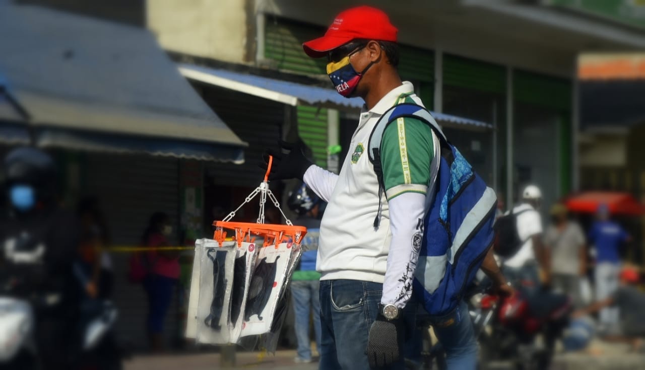 Vendedor ambulante con tapaboca de la bandera de Venezuela.