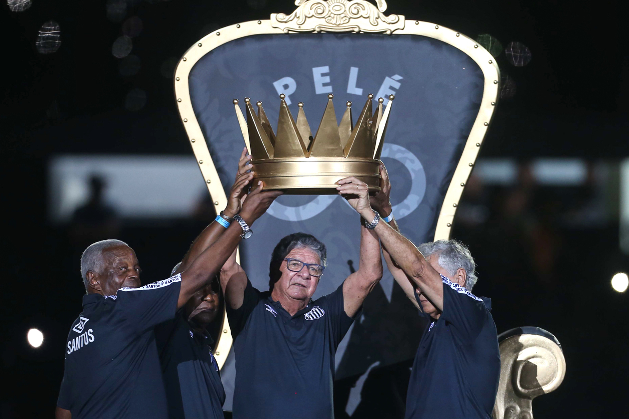 Excompañeros de Pelé cargando la corona hacia el trono.