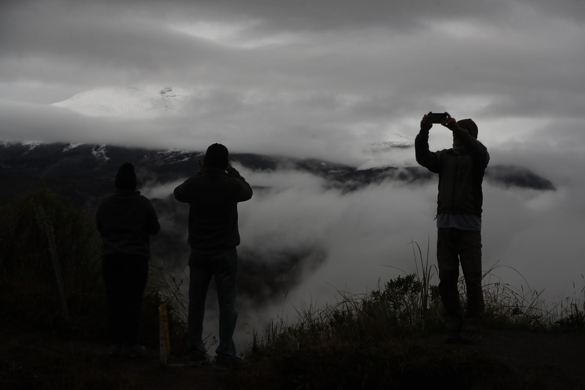 Dos turistas toman fotografías al volcán Nevado del Ruiz, en Murillo.