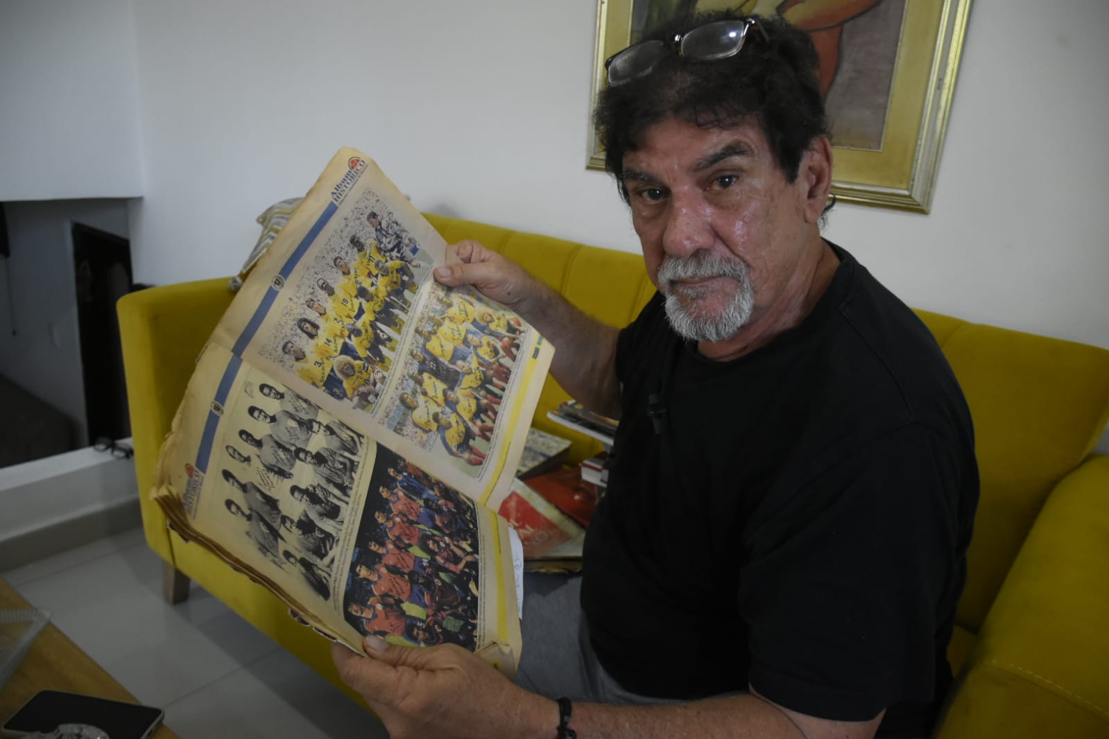 Jairo De la Rosa en su residencia con una revista futbolera de su colección
