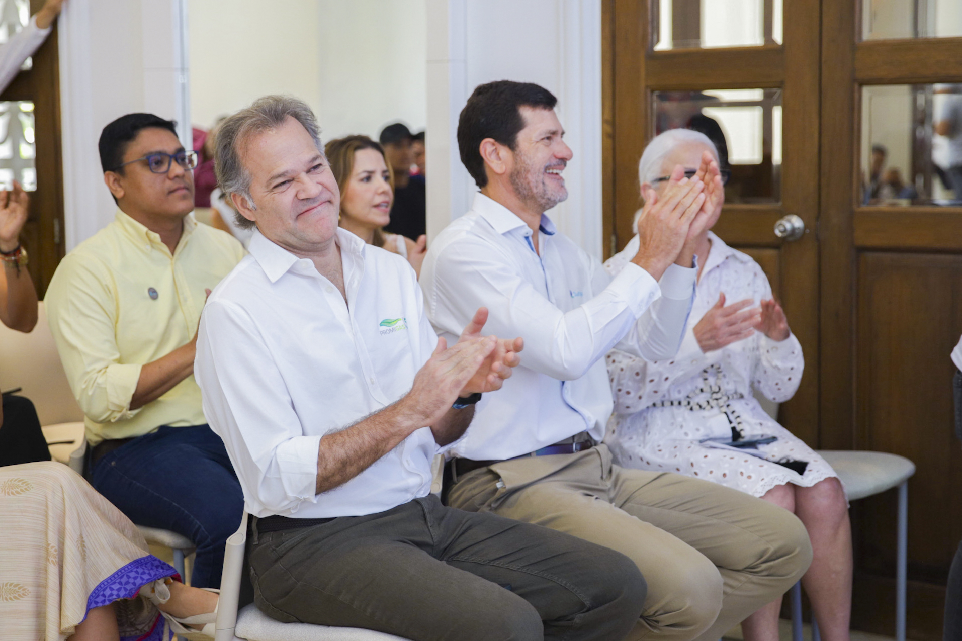Juan Manuel Rojas, presidente de Promigas; Santiago Mejía, Gerente de Surtigas, y Julia Salvi, Presidenta de la Fundación Salvi, aplauden a los beneficiarios