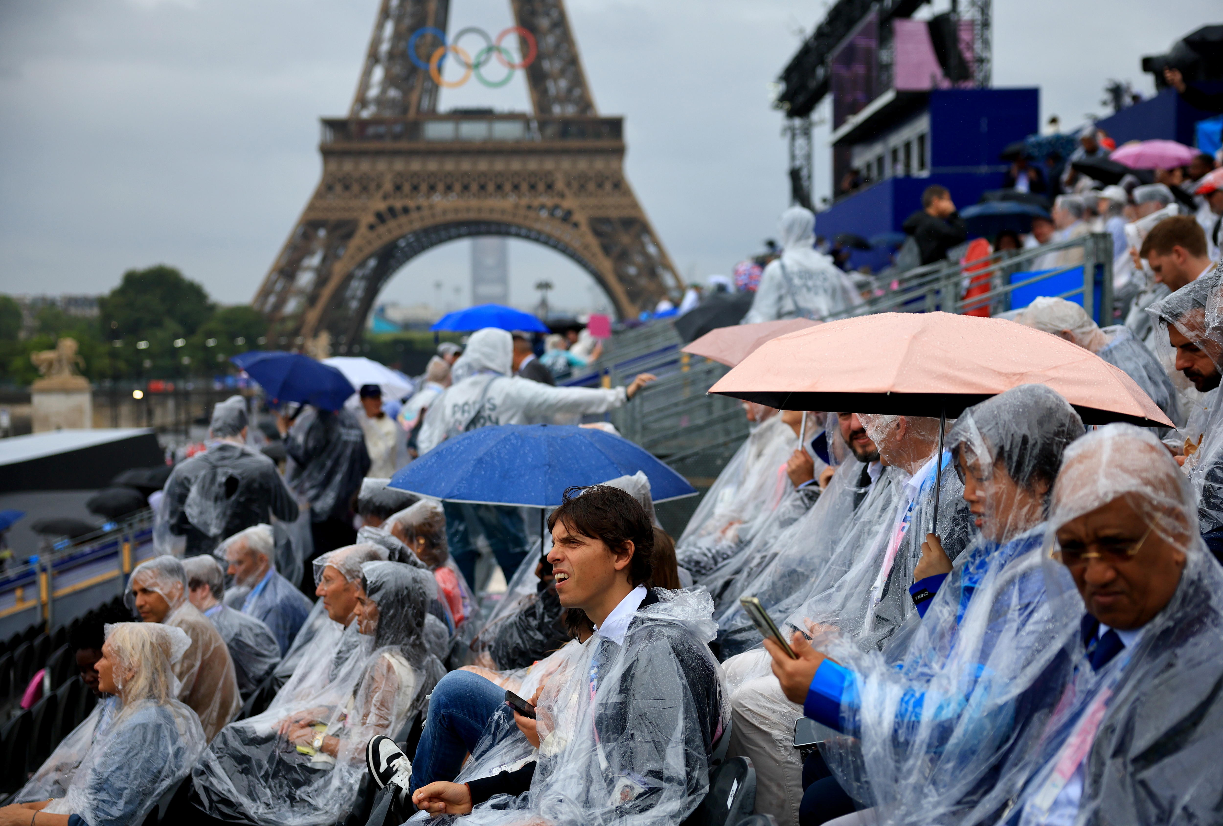 Los espectadores cerca a la torre Eiffel fueron sorprendidos por la lluvia.