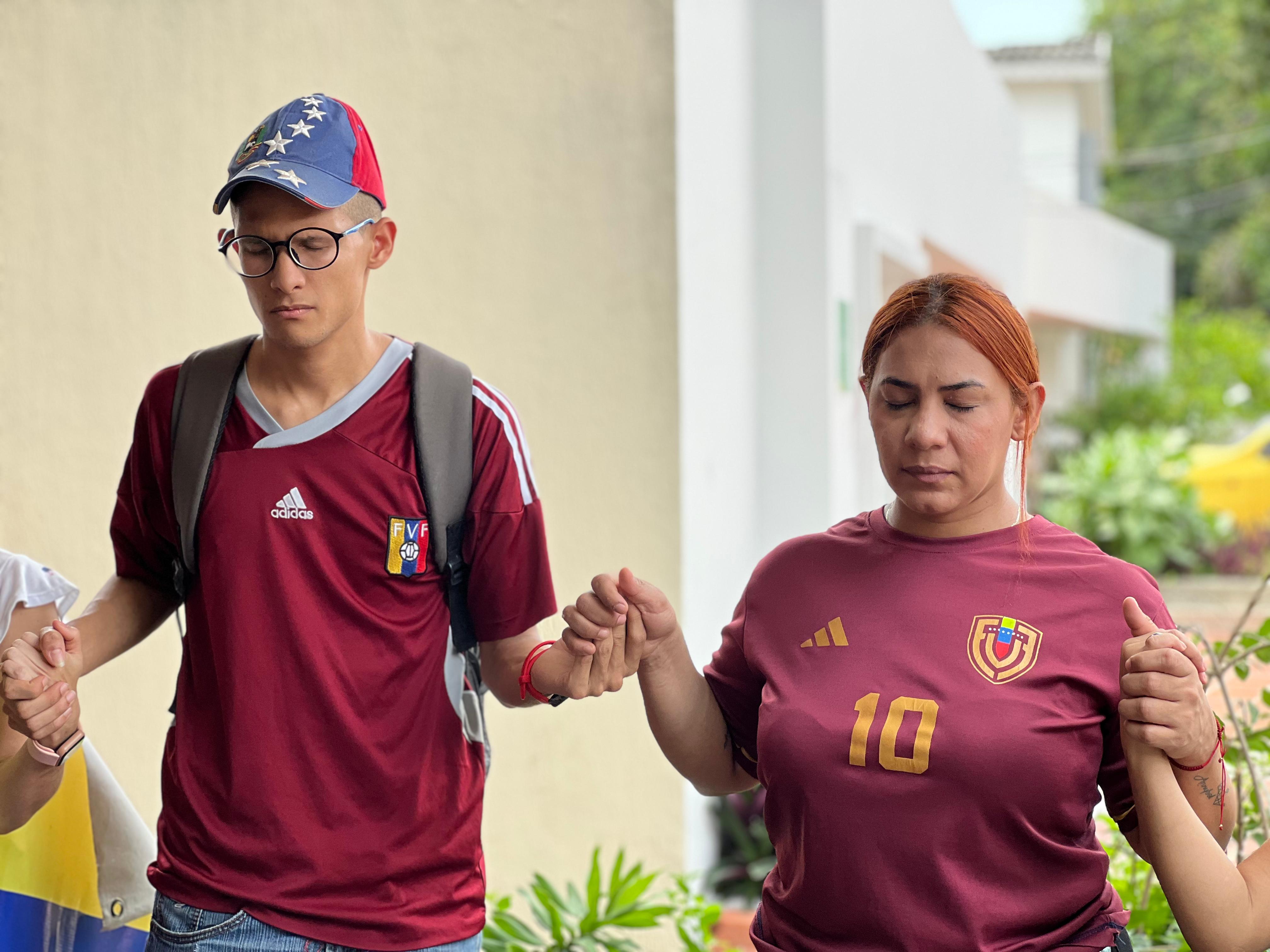 Venezolanos haciendo una oración a las afueras del consulado de su país, en Barranquilla. 