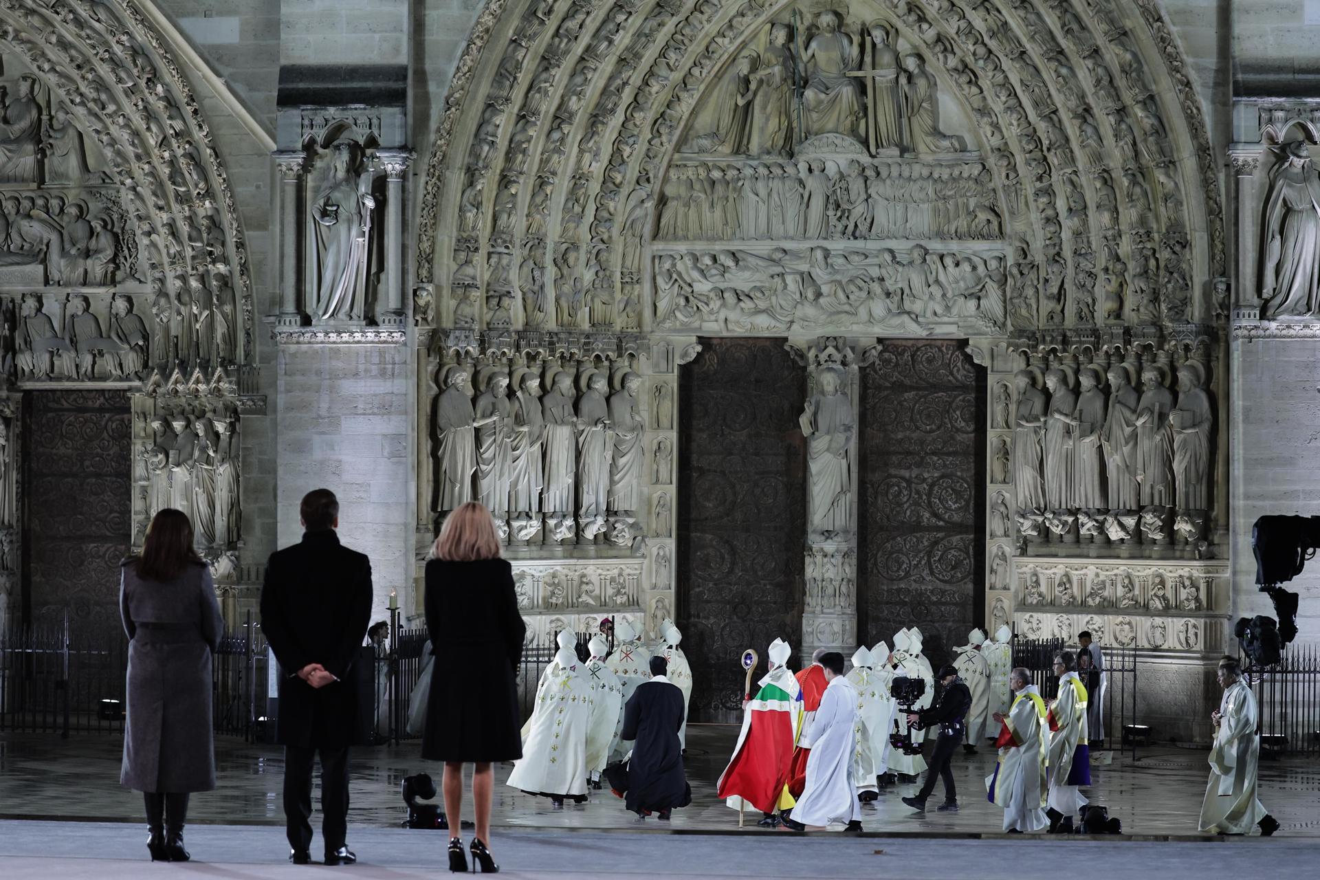 El presidente francés Emmanuel Macron y su esposa Brigitte observan al arzobispo de París inaugurando Notre Dame.