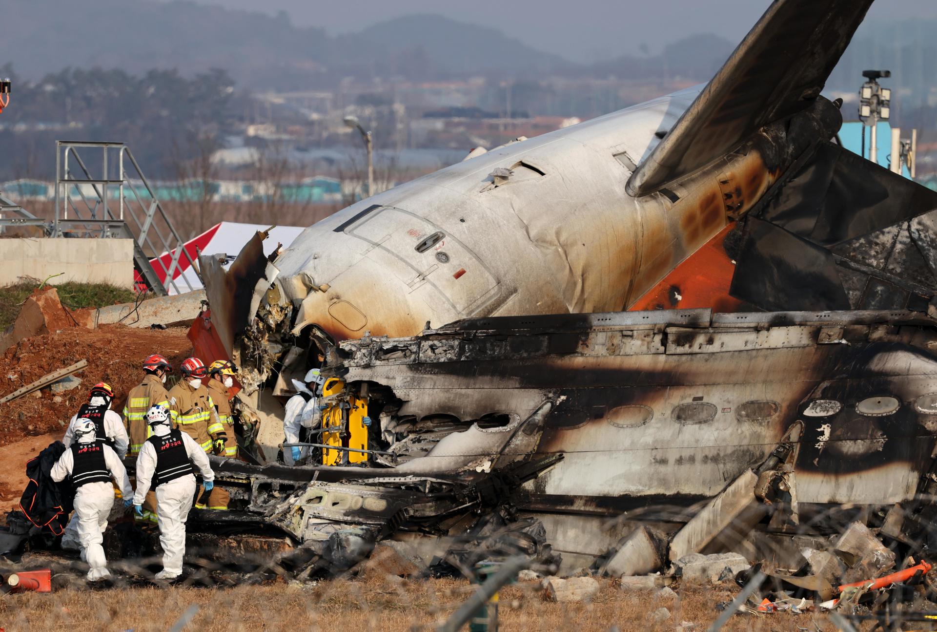 Bomberos trabajando en los restos del avión Jeju Air en el Aeropuerto Internacional de Muan.