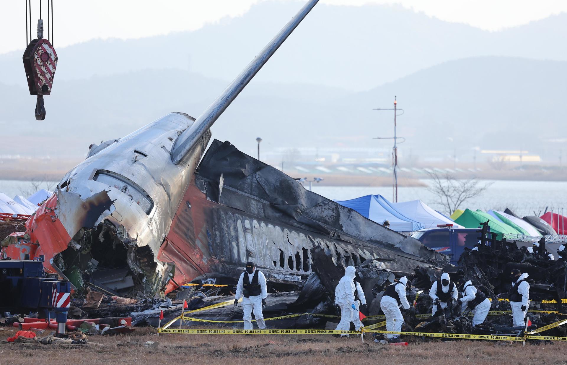 Un equipo forense de la policía lleva a cabo una investigación en el lugar del accidente del avión. 