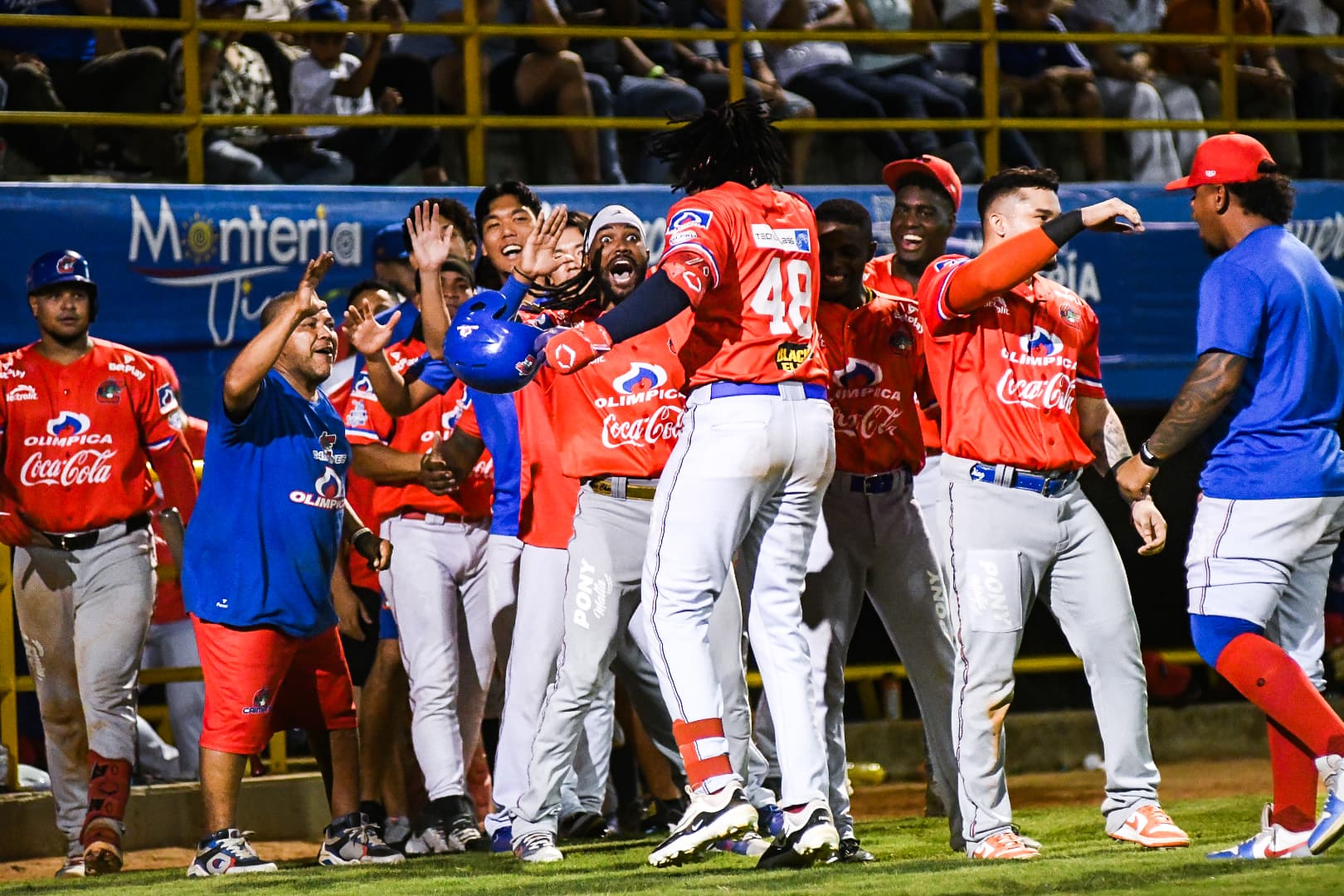 Félix Reyes es saludado por sus compañeros al llegar al dugout. 