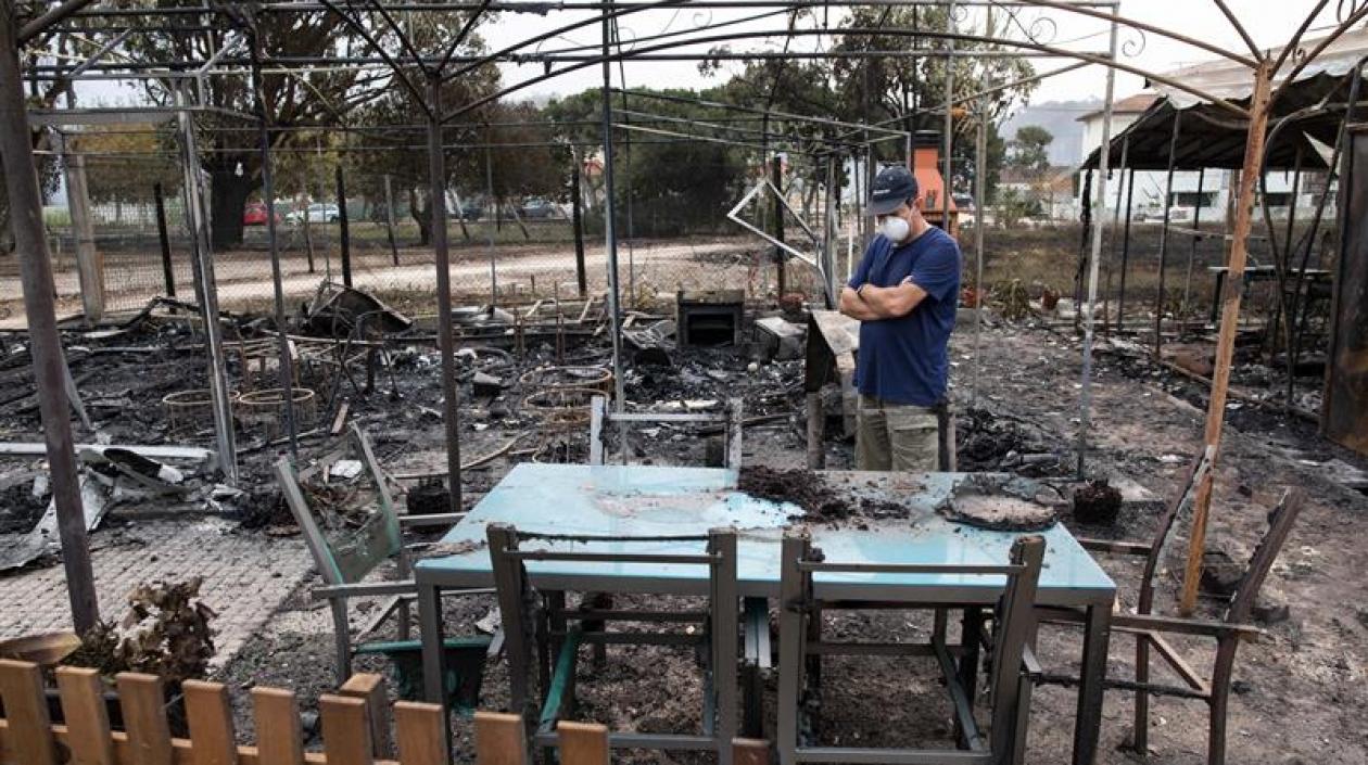 Vecinos observan los daños tras un incendio forestal en un camping en Marinha Grande, en el centro de Portugal.