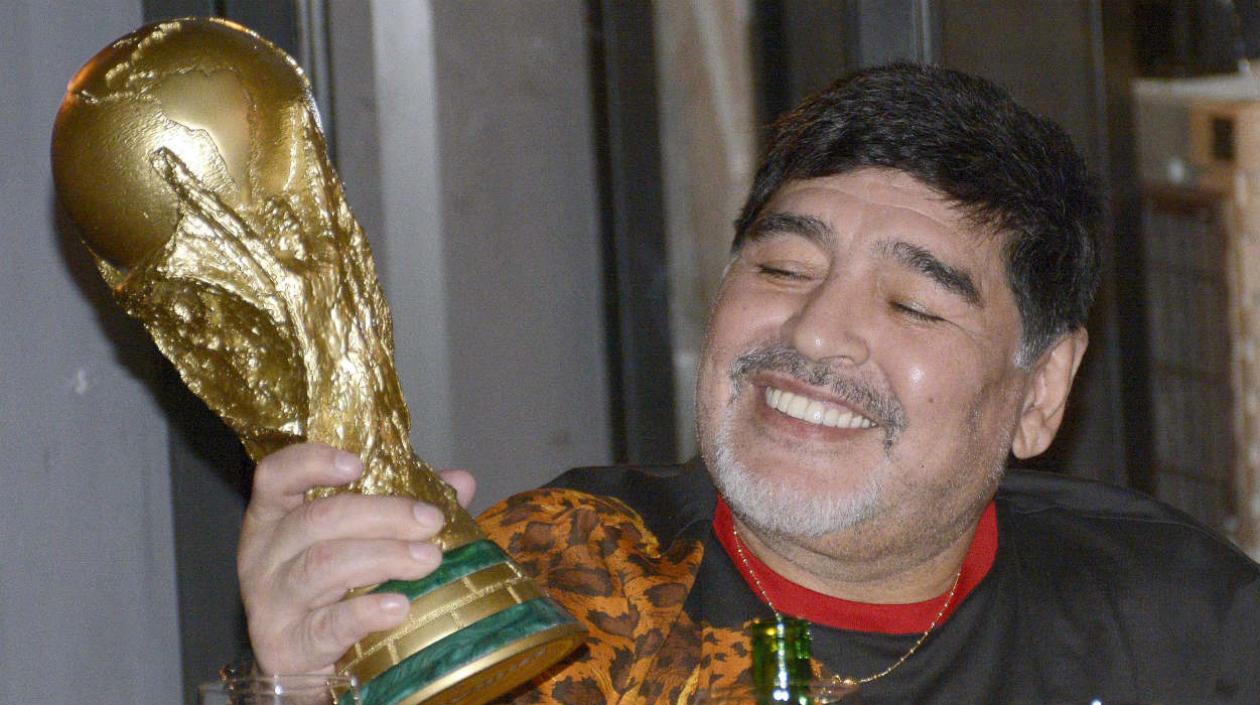 Diego Maradona, técnico de los Dorados de México, con una réplica de la Copa del Mundo.