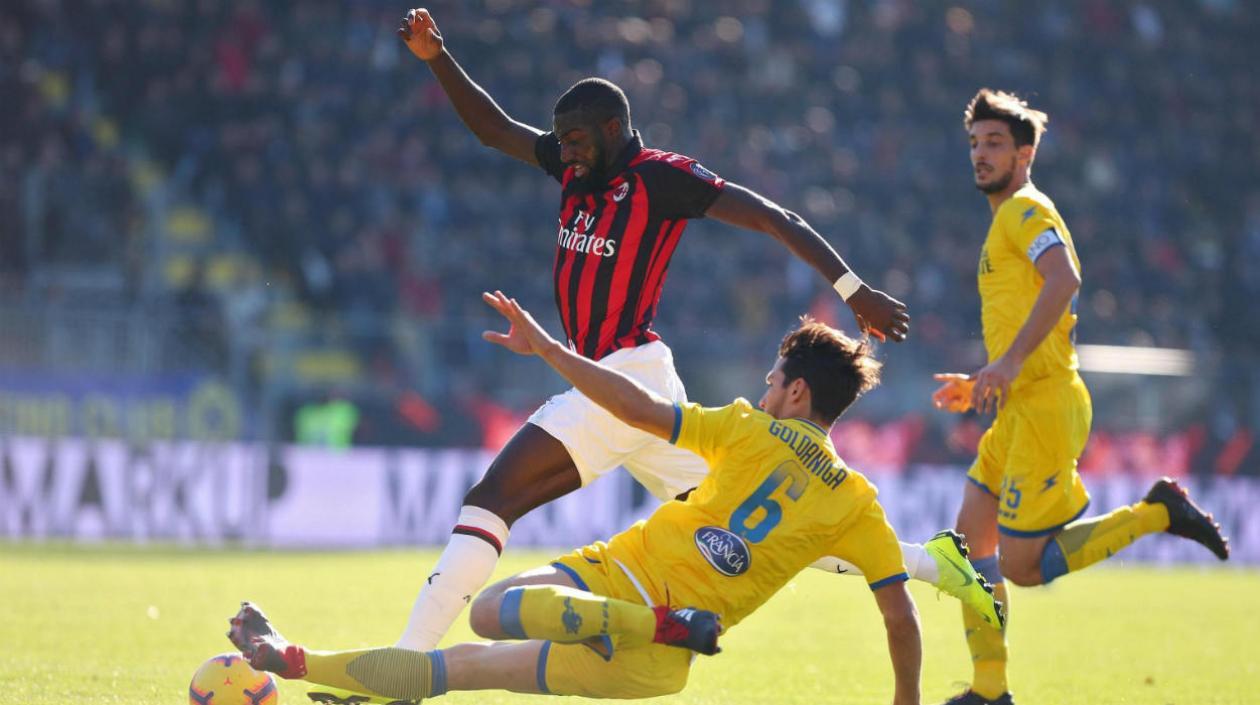 El centrocampista del AC Milán Tiemoue Bakayoko (i) y el defensa del Frosione Edoardo Goldaniga (c) pelean por el balón.