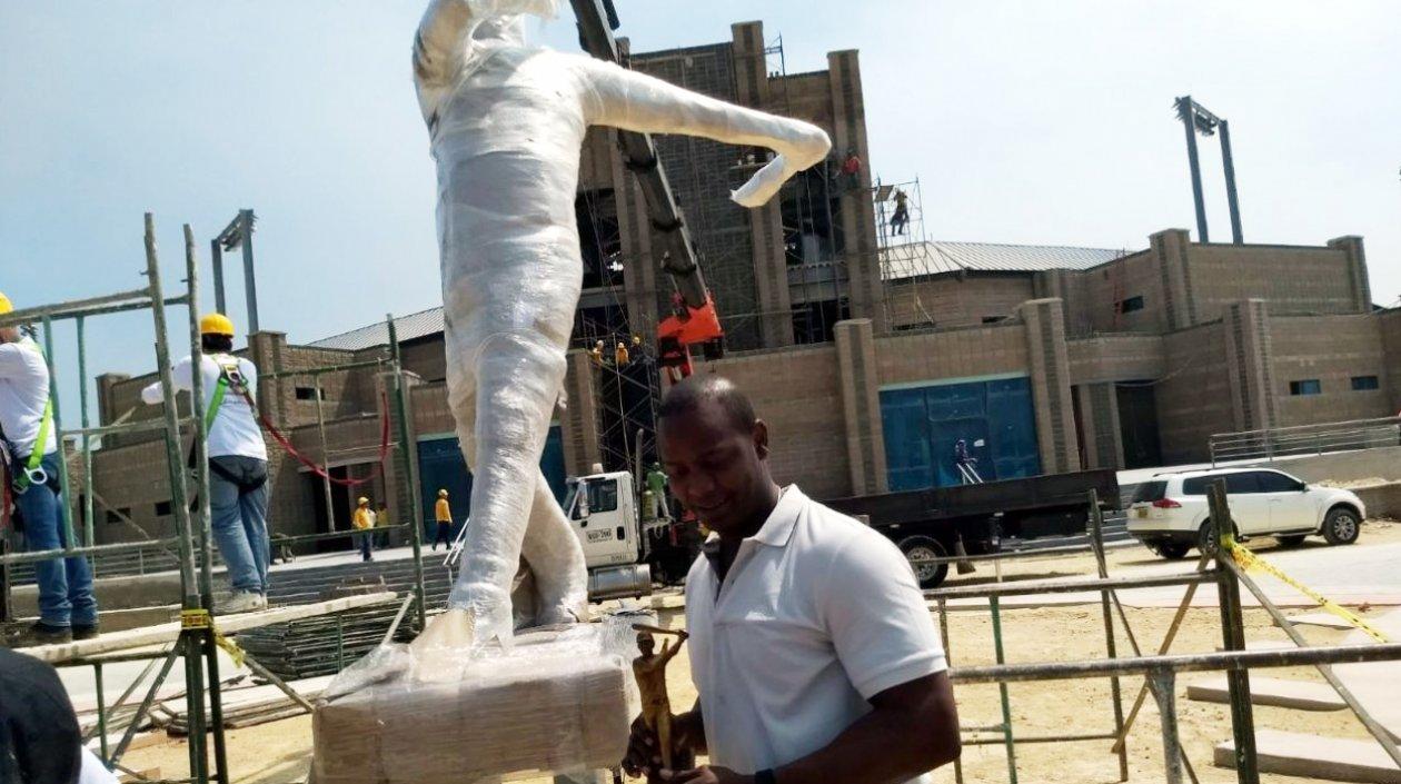 Édgar Rentería posa con la escultura y la estatua hecha a su honor. 