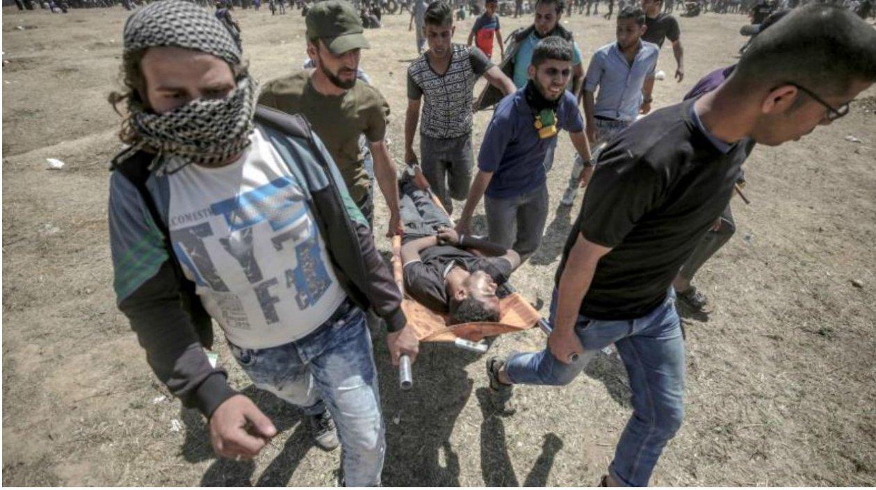 Varios manifestantes trasladaban ayer a un joven herido durante las protestas en la frontera de Gaza e Israel.