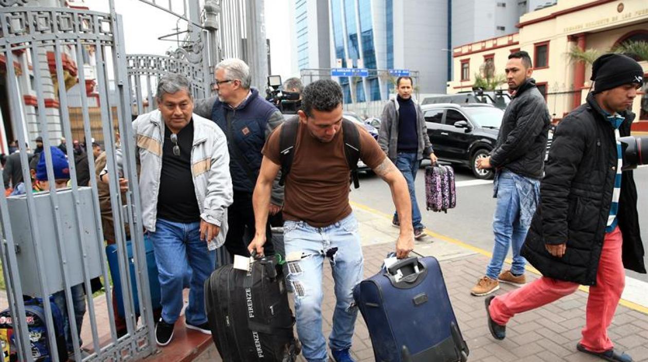 Migrantes venezolanos se reúnen en la embajada de Venezuela para dirigirse al aeropuerto, en Lima (Perú).