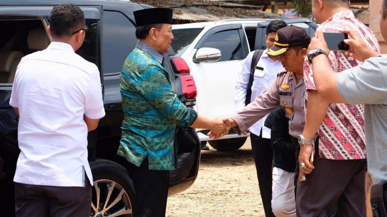 El ministro de seguridad indonesio Wiranto (de verde) es recibido por un oficial local poco antes de ser atacado por un hombre con un cuchillo.