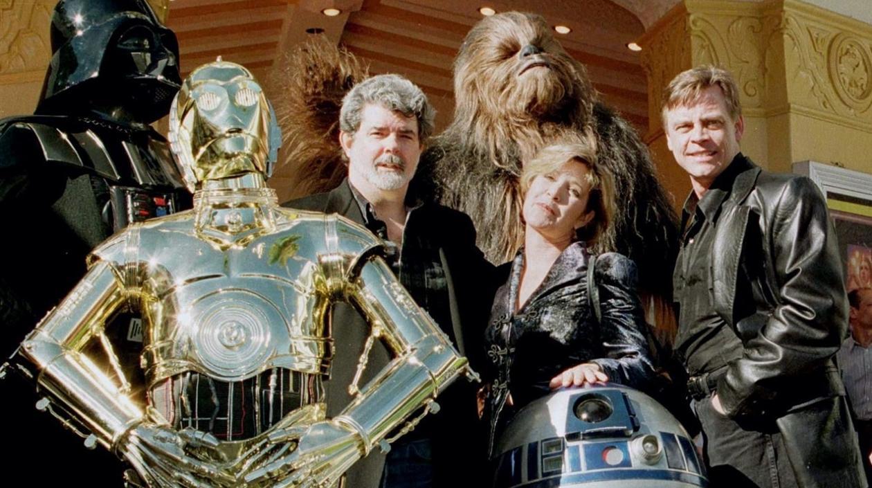 George Lucas con algunos de los personajes de Stars Wars y el actor Mark Hamill.