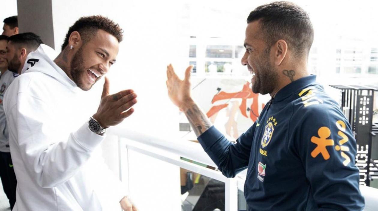 Neymar se saluda con Dani Alves. 