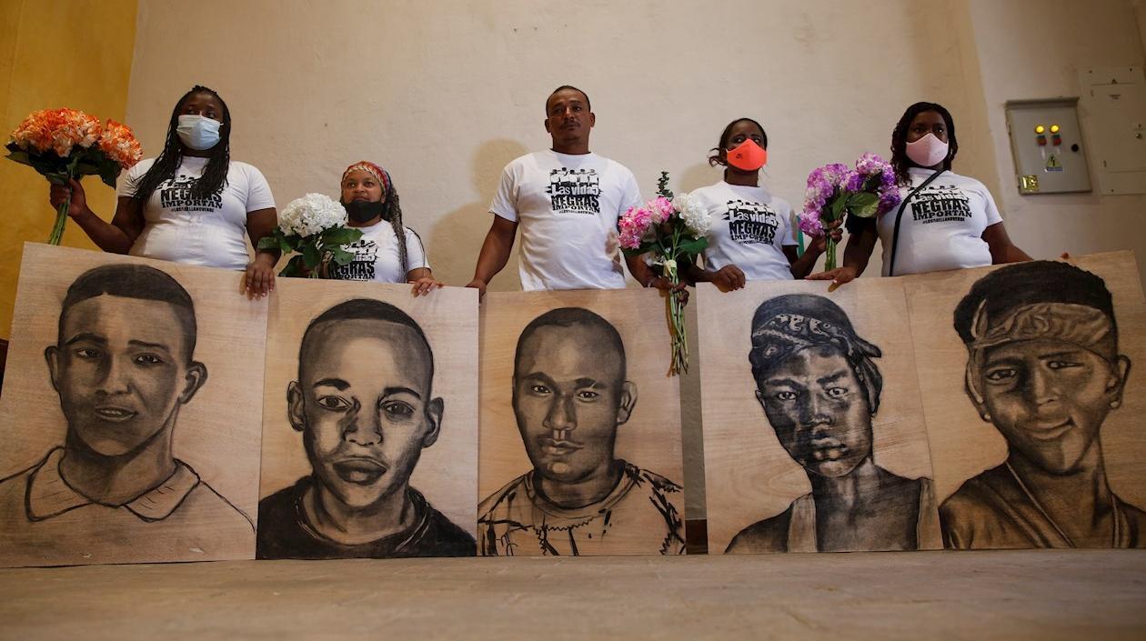 Familiares de las víctimas de la masacre de Llano Verde, sostienen hoy retratos suyos durante un acto conmemorativo, en Cali (Colombia). 