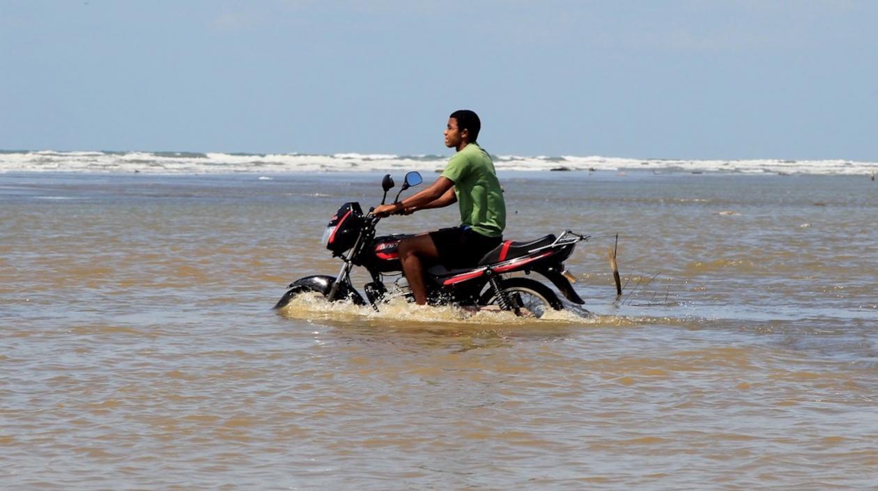 Un hombre transita en una moto por las inundaciones en el sector Marlinda y la boquilla, en Cartagena.