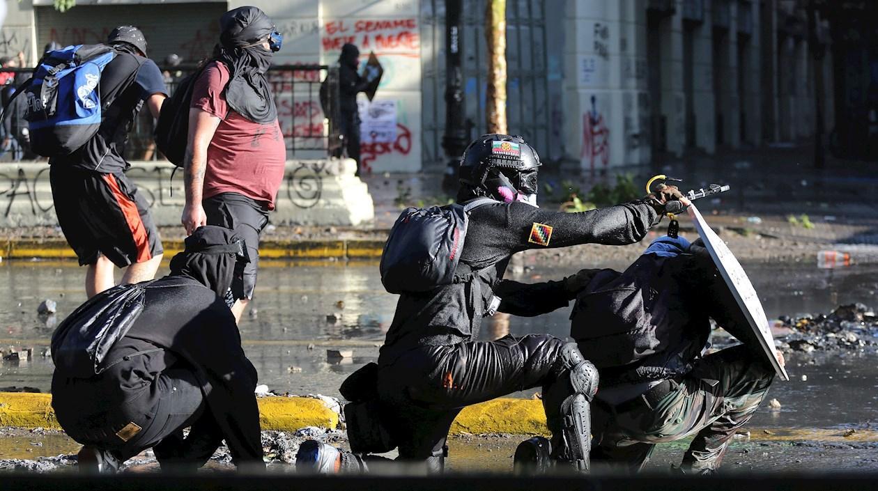 Manifestantes enfrentan a los carabineros durante una nueva jornada de protestas antigubernamentales en Santiago (Chile).