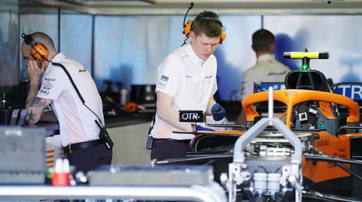 Técnicos del equipo McLaren revisan el monoplaza de carreras. 