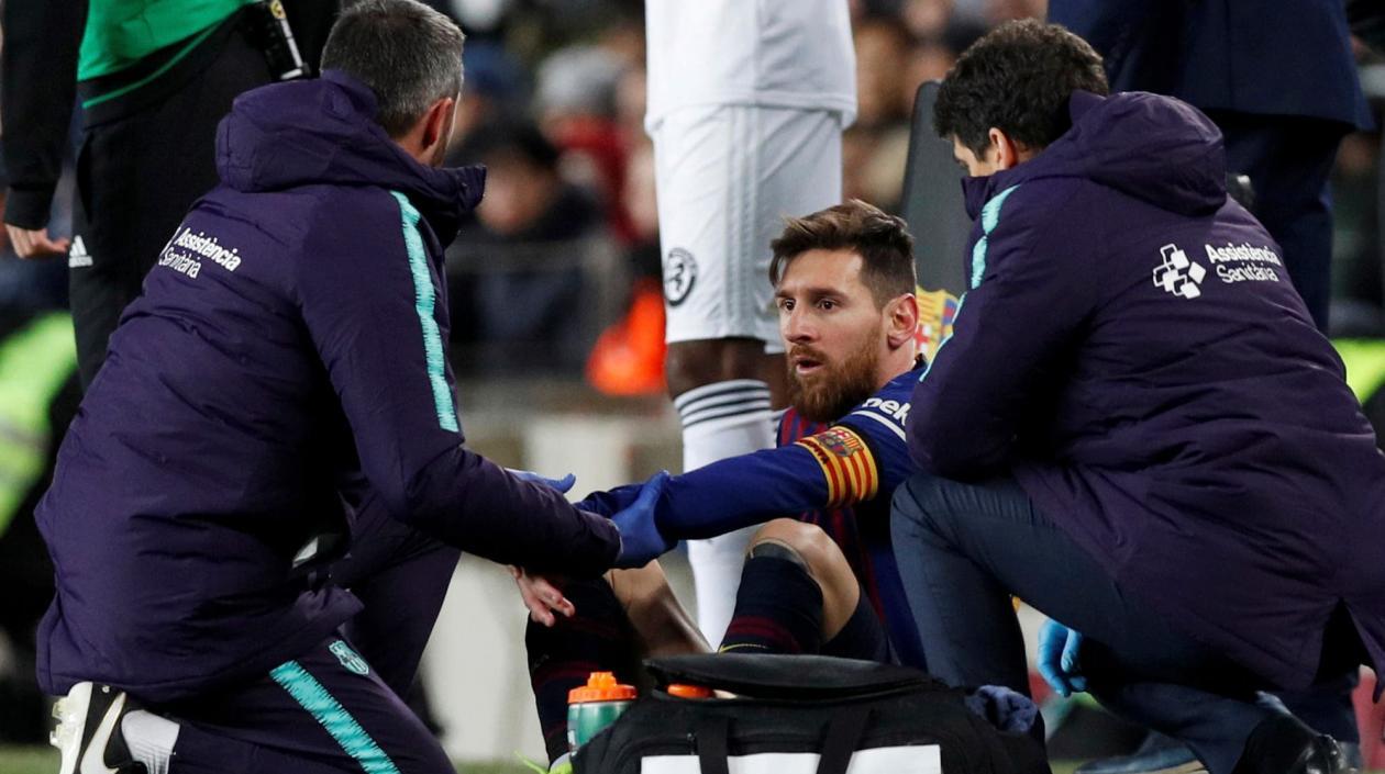Lionel Messi atendido por los médicos en un partido del Barcelona. 
