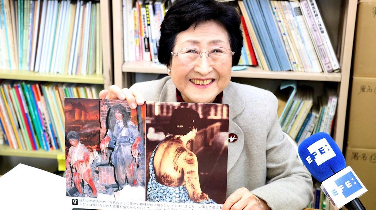 La superviviente de la bomba atómica de Hiroshima, Michiko Kodama sonríe mientras muestra una lámina que representa los efectos de la explosión de la bomba atómica.