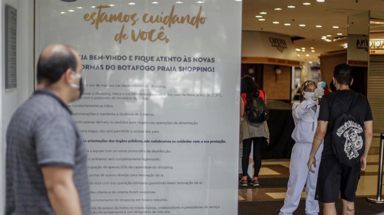 Una trabajadora sanitaria toma la temperatura a personas que entran a un centro comercial en Río de Janeiro.