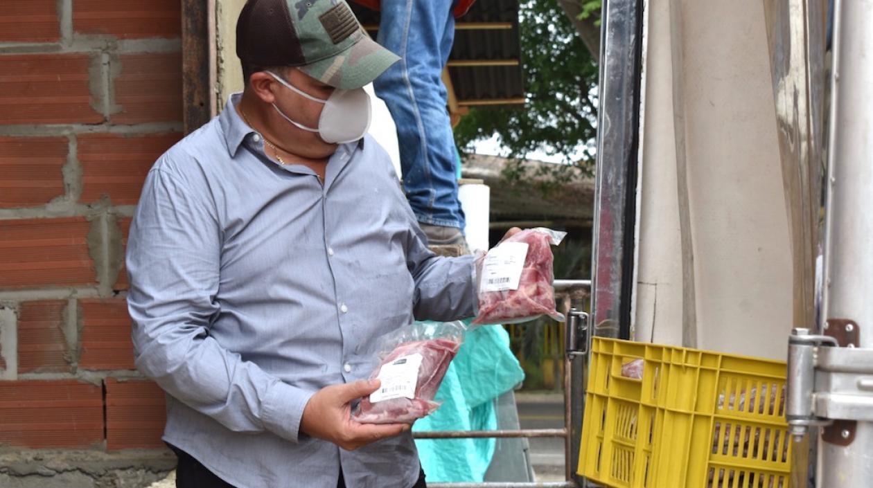 El Alcalde Roberto Celedón, entregando las porciones de carne de cerdo.