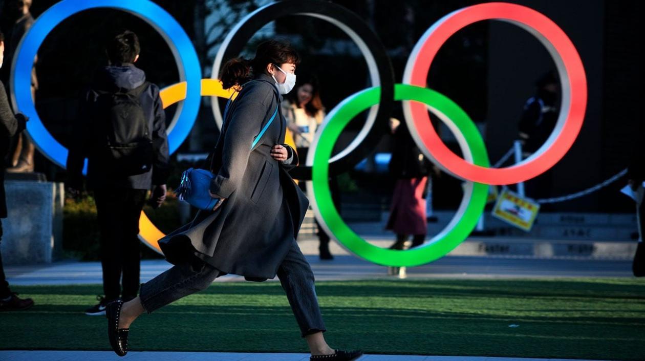 Ciudadanos japoneses alrededor de los anillos olímpicos. 