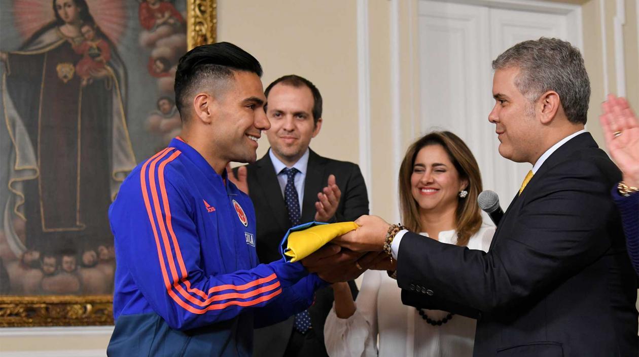 Iván Duque, presidente de Colombia, entrega en el pasado el pabellón nacional al jugador Falcao García.