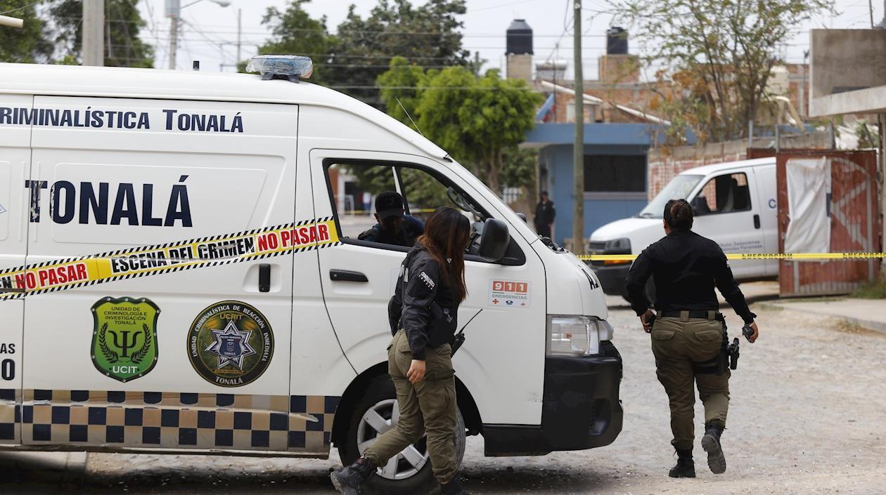 Policías municipales resguardan el área acordonada de una fosa clandestina en Jalisco, México.