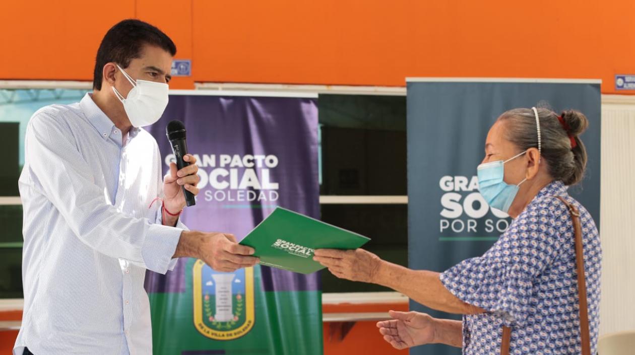 El alcalde Rodolfo Ucrós entregando uno de los títulos de propiedad. 