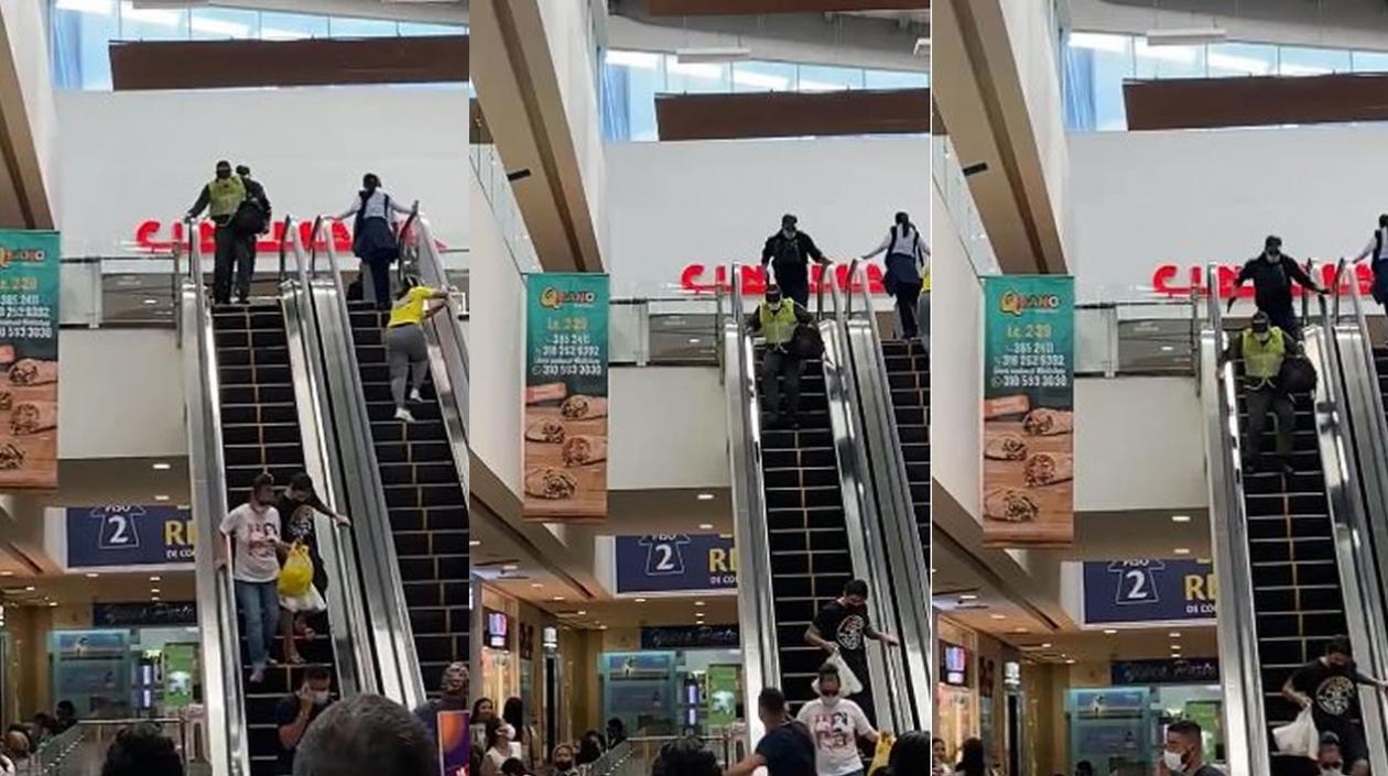 Los dos ladrones, uno vestido de policía, cuando bajaban corriendo por la escalera eléctrica del centro comercial. 