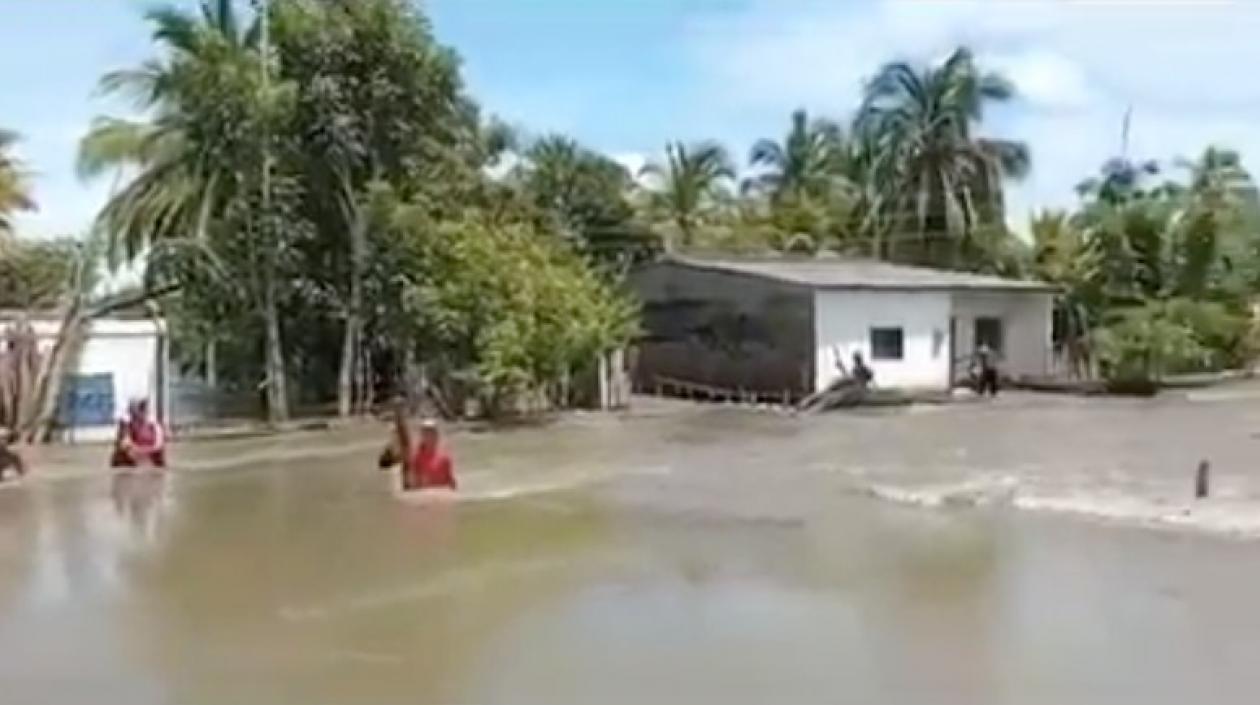 Damnificados caminan entre el agua desbordada en Santa Rosa, Pinillos