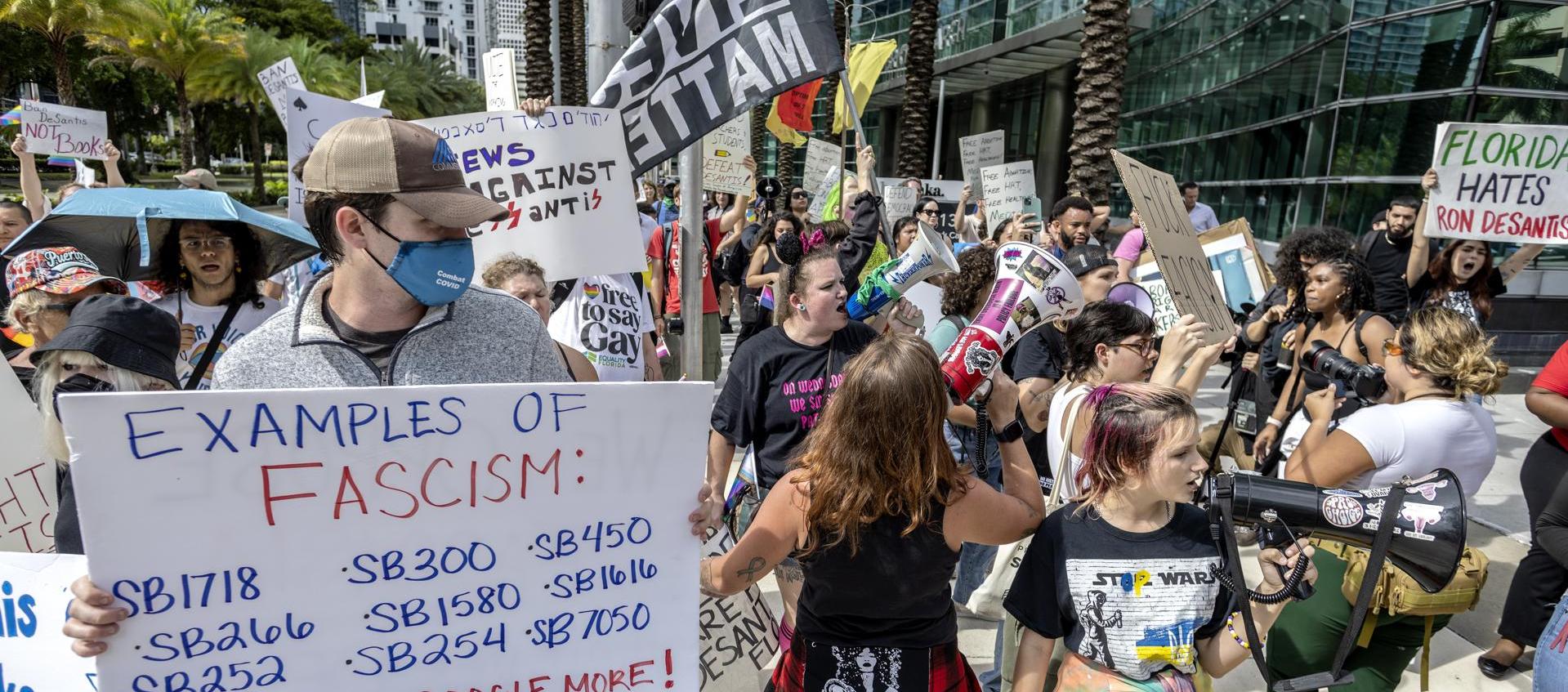 Los opositores al Gobernador de Florida DeSantis protestan contra su candidatura presidencial.