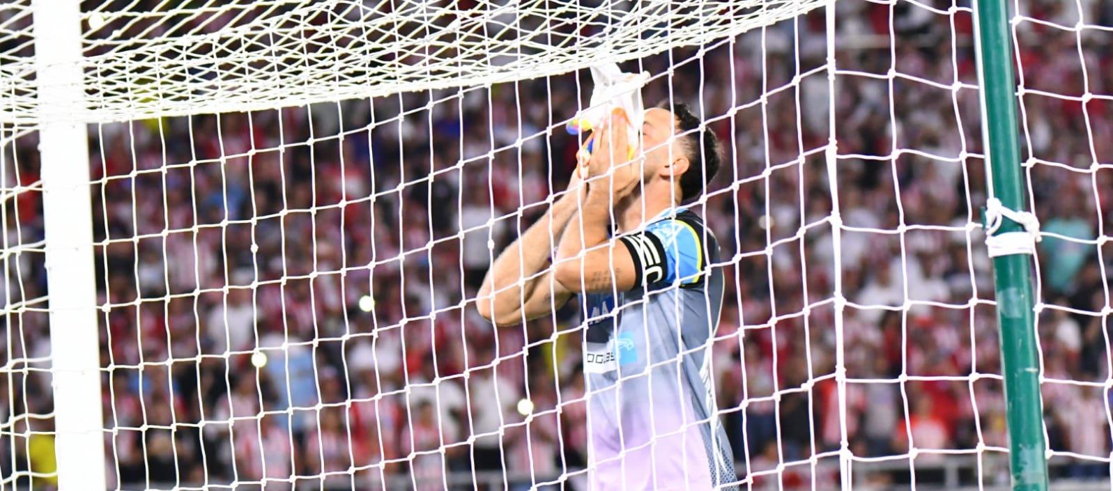 Sebastián Viera besa los guantes que llevó en su último partido con Junior
