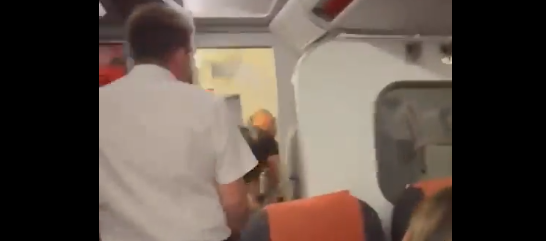 El asistente de vuelo abriendo la puerta del baño del avión.