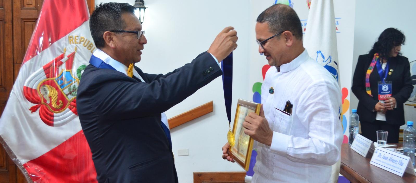 Jaime Fernández, secretario general de la Federación para la Paz Universal, le impone a Fausto Pérez la medalla.
