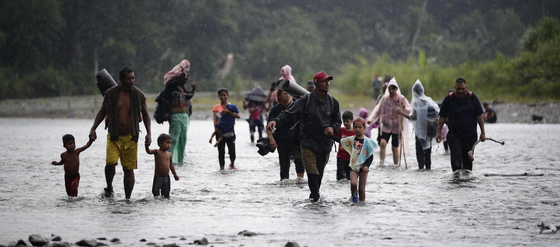Migrantes cruzan el río Turquesa, en Darién (Panamá).