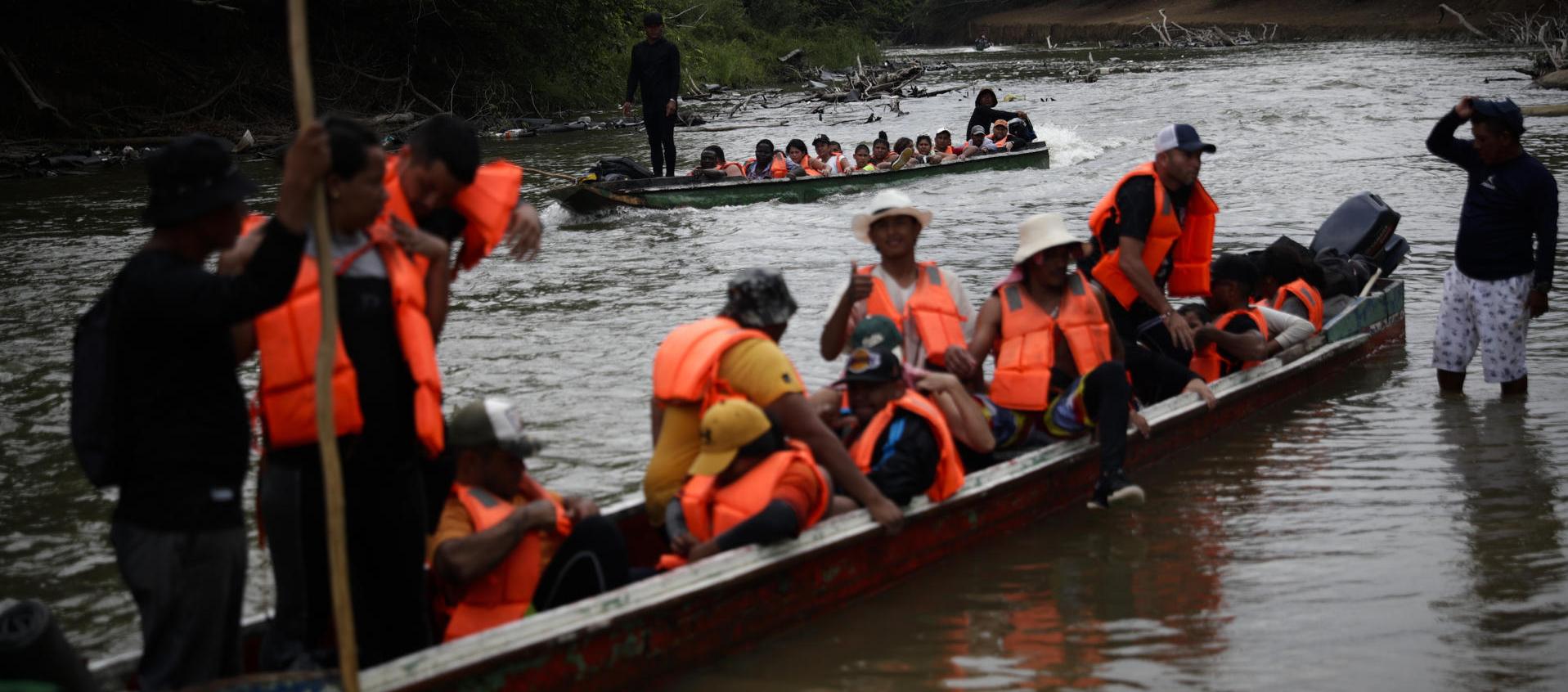 Migrantes llegan en canoas a una estación de recepción migratoria luego de cruzar la selva del Darién, en Lajas Blancas, Panamá