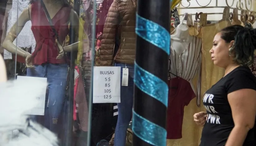 Una mujer mira los precios en dólar en una tienda.