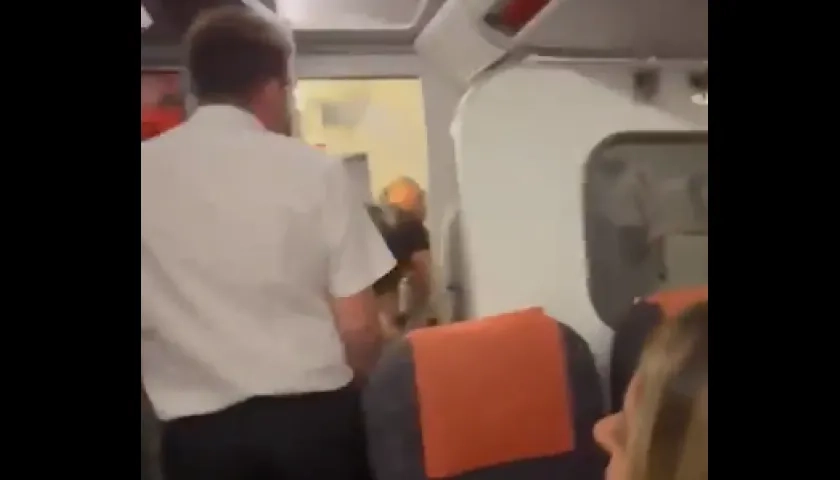 El asistente de vuelo abriendo la puerta del baño del avión.